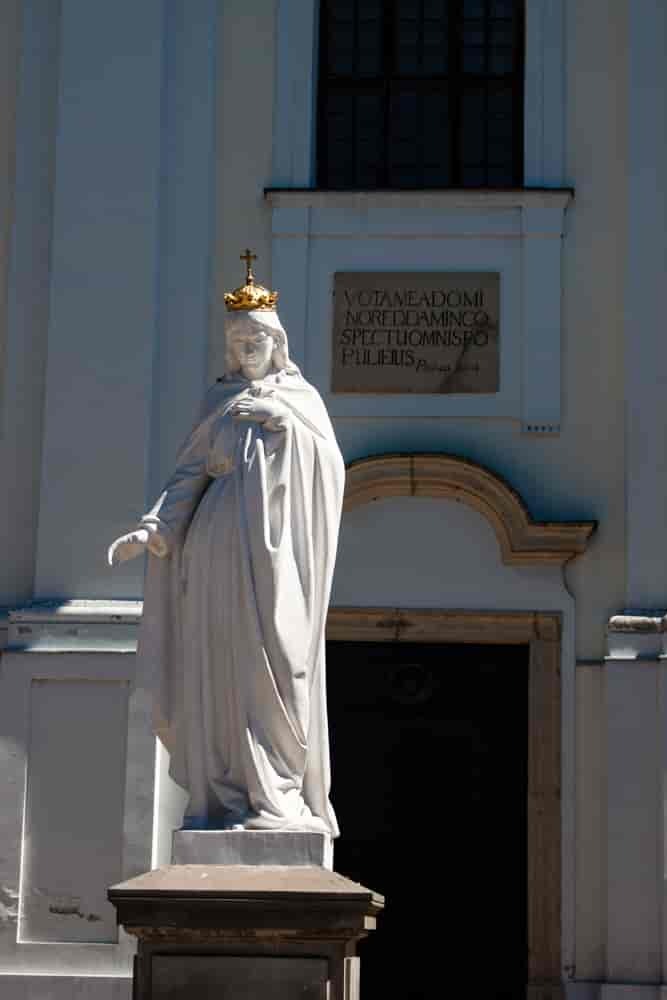 Figurka Maryji na tle klasztora